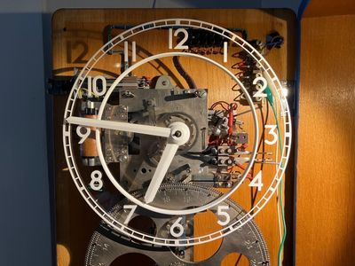 The restored Ericsson master clock with its new skeleton dial, showing the movement behind.