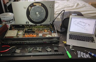 The unit in parts, next to a laptop showing the PDF service manual.