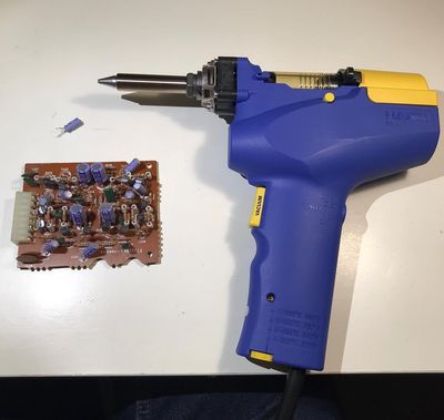 Desoldering gun next to a loose capacitor.
