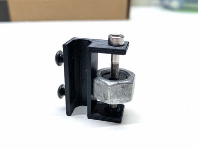 A 3D-printed bracket holding a bolt and heavy nut.