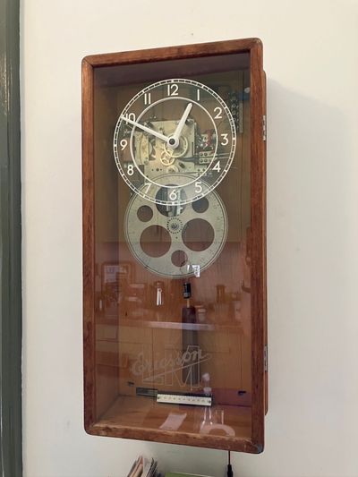 The clock, hanging on a wall in the kitchen.